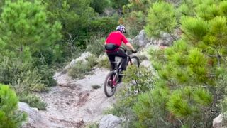 Tom Oehler rides an eMTB up a steep slope