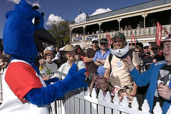 The Jayco mascot throws some tour caps to fans in the crowd prior to racing.
