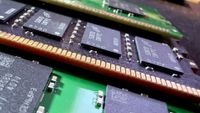 A close-up photo of multiple SK hynix and Micron DDR5 DIMMs, showing the memory modules installed on black/green PCBs