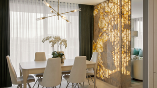 dining room with lit wall screen feature and pendant light above dining table