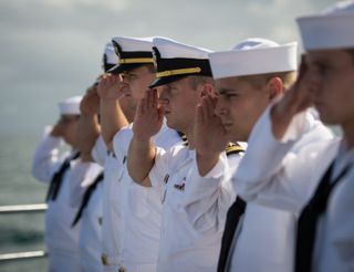 US Navy sailors salute during Neil Armstrong's burial at sea on Sept. 14, 2012.
