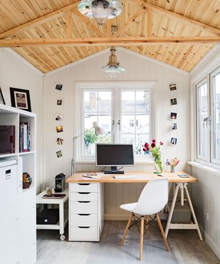 home office with white wall and wooden desk