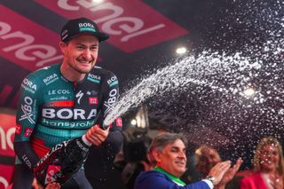 BORA hansgrohes German rider Nico Denz sprays sparkling wine as he celebrates on the podium after winning the twelfth stage of the Giro dItalia 2023 cycling race 179 km between Bra and Rivoli on May 18 2023 Photo by Luca Bettini AFP Photo by LUCA BETTINIAFP via Getty Images
