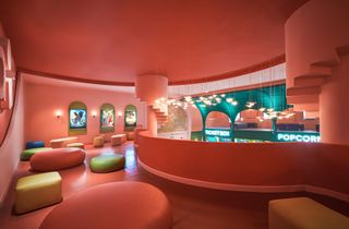 The mezzanine level at Ho Chi Minh City’s new Beta Cinema by Module K. Pink walls, round and square colourful chairs.