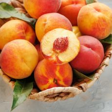 Peaches in basket with exposed peach pit