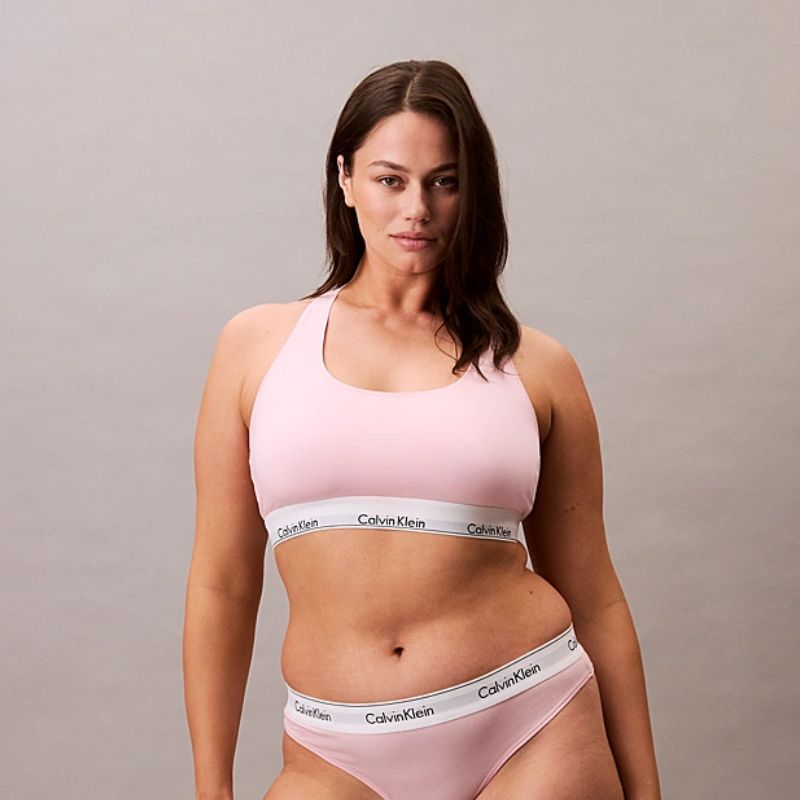 pink and white branded Calvin Klein bralette and pants on a model
