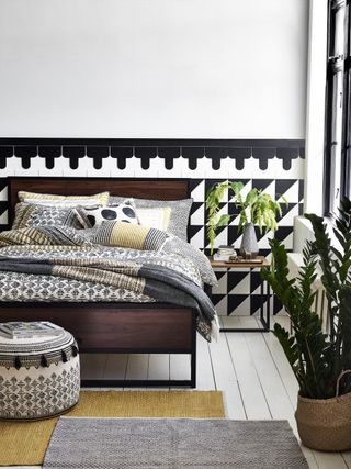 bedroom with black and white wallpaper and dark wood by argos
