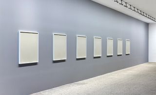 Grey wall lined with white frames