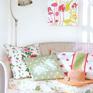 sofa with floral cushions and white wall