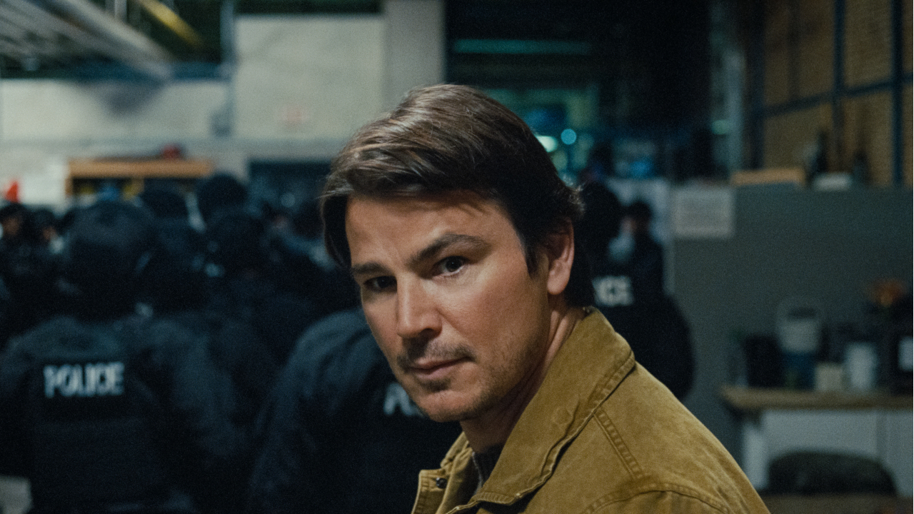 Josh Hartnett olha para o lado com cautela enquanto fica atrás da equipe SWAT no Trap.