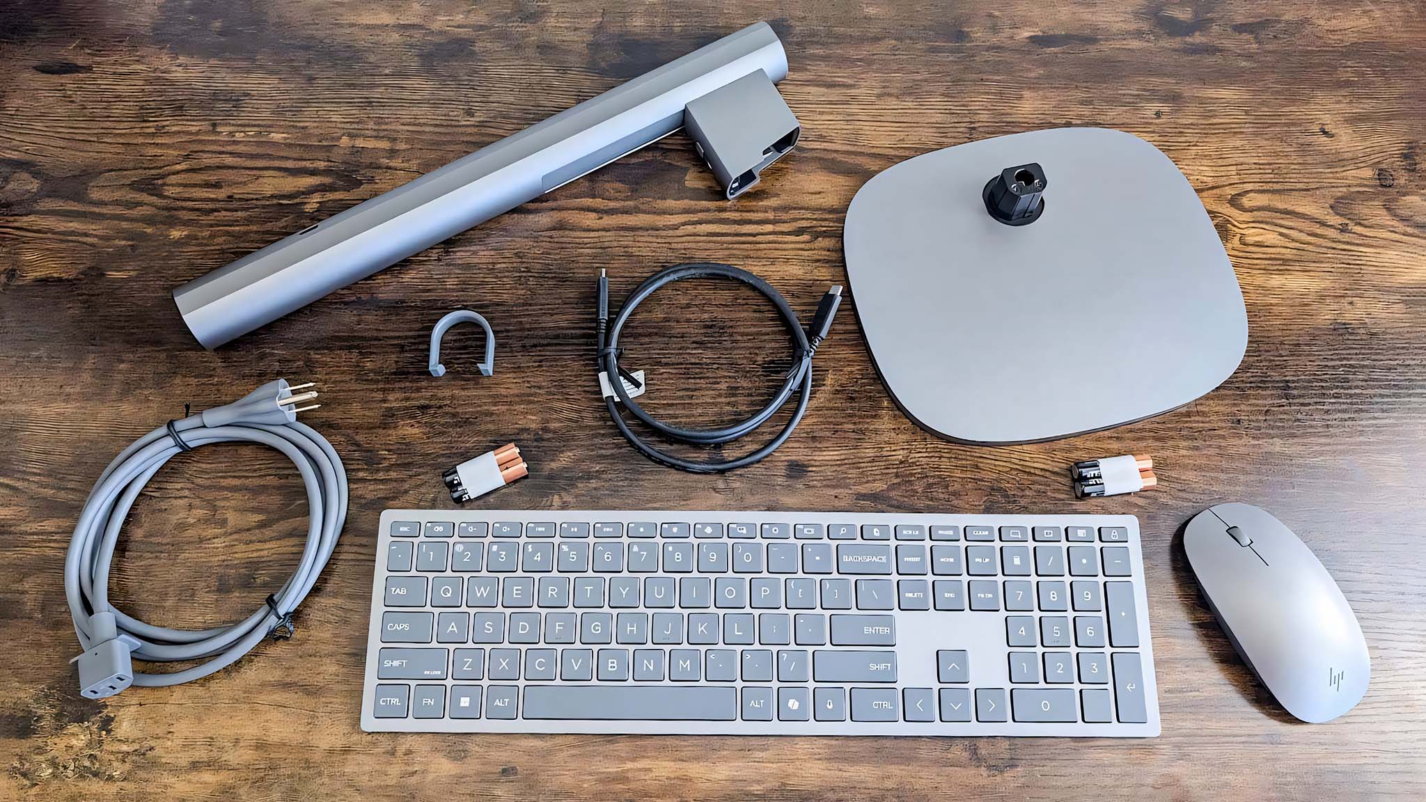 Image showing the HP OmniStudio X AIO's stand, base, cable tidy clip, USB-C cable, power cable, keyboard, and mouse.