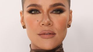 Close up shot of Khloe Kardashian with hair pulled back, heavy eye makeup