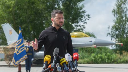 president of Ukraine Volodymyr Zelenskyi stands in front of the first General Dynamics F-16 Fighting Falcon received by Ukraine as he congratulates Ukrainian military on the Day of Ukrainian Air Force on August 4, 2024 