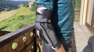 Closeup of man wearing elbow guard with countryside backdrop
