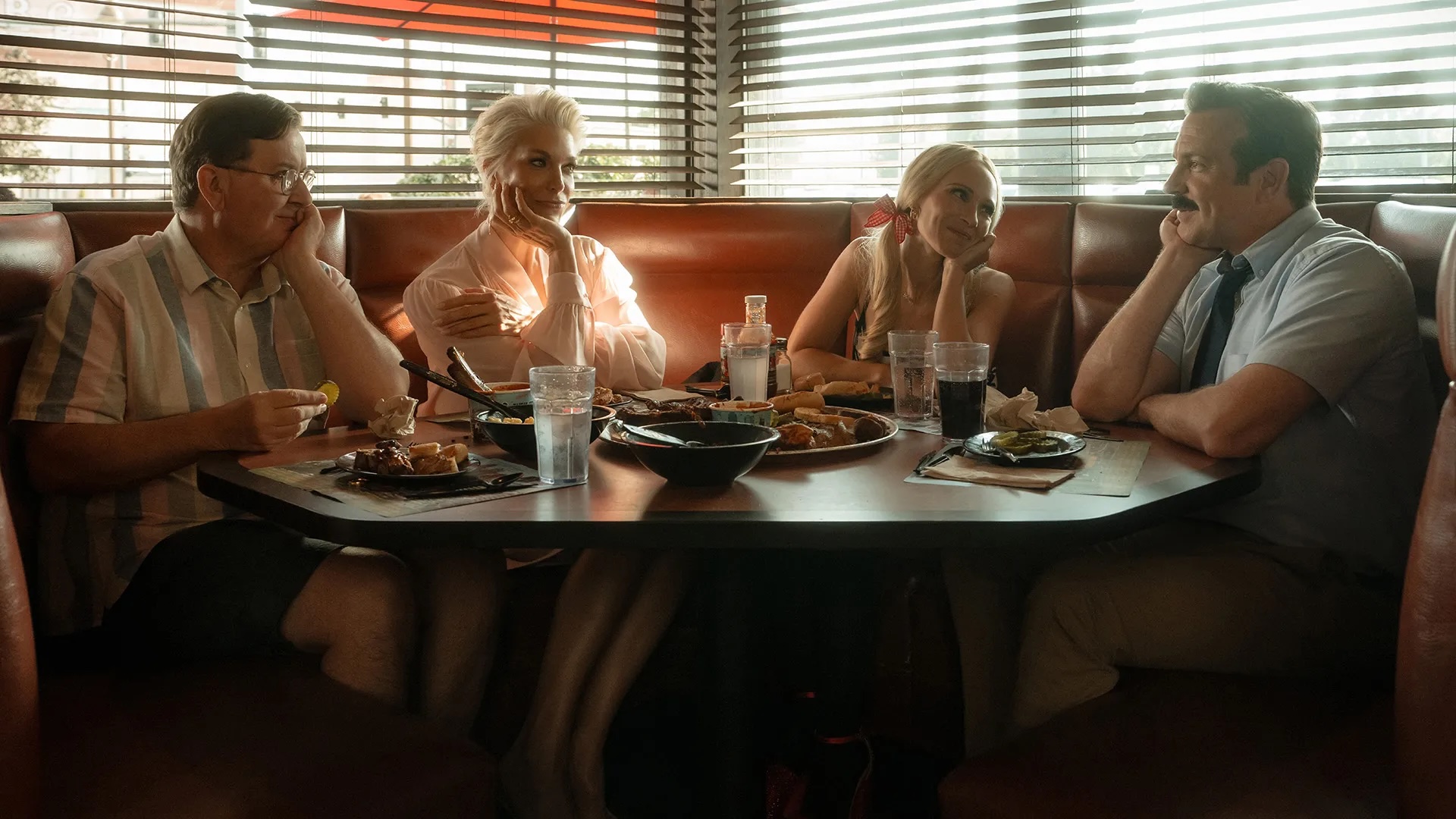 Four people sat around a table in a diner 