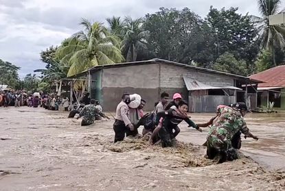 This video still shows people fleeing from flooding in eastern Indonesia.