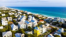 Residential neighborhood with beachfront properties along turquoise Gulf waters in Seaside, Florida during spring season.