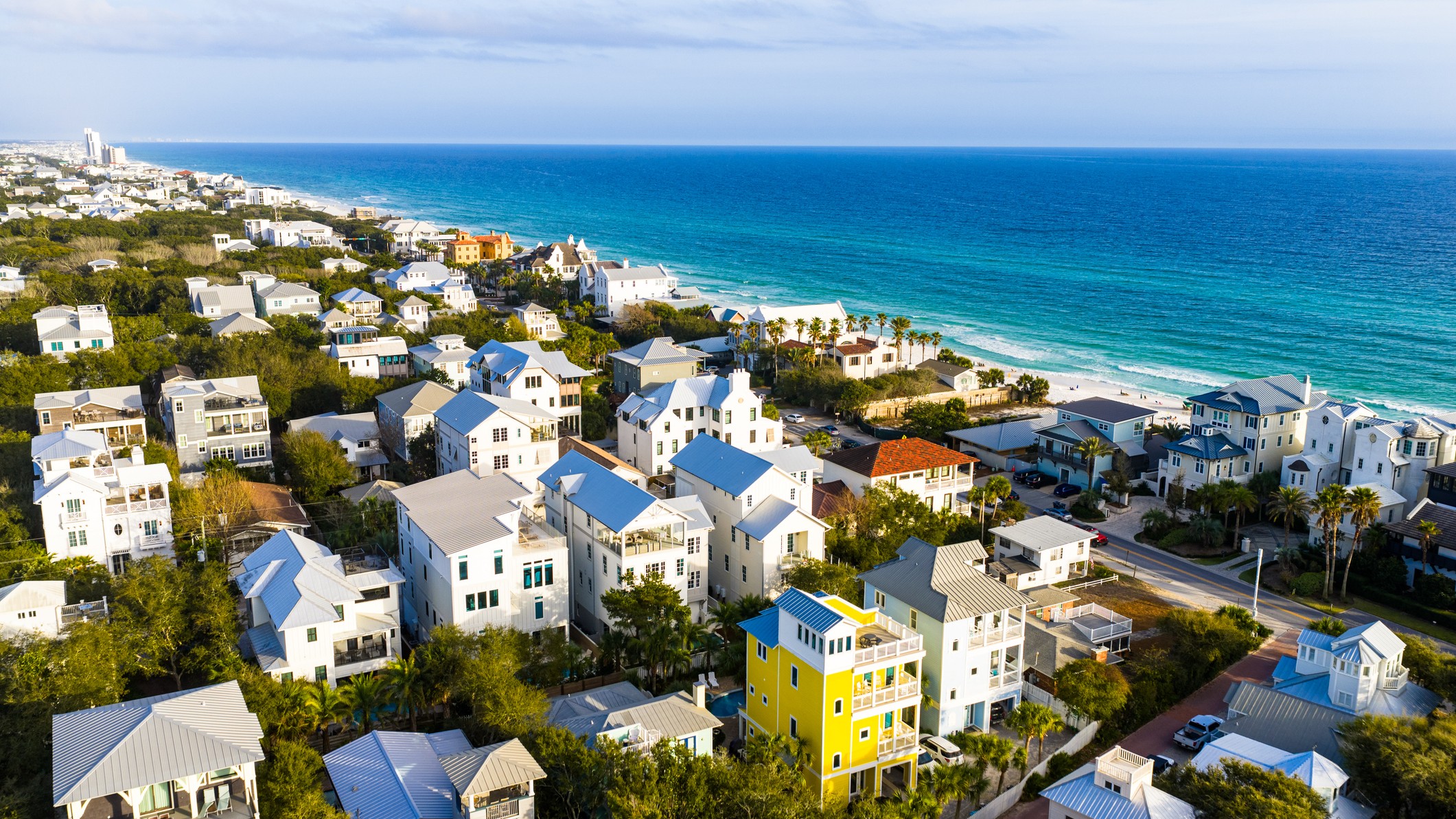 Residential neighborhood with beachfront properties along turquoise Gulf waters in Seaside, Florida during spring season.