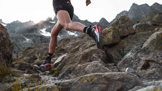 Man running on rocky mountain terrain