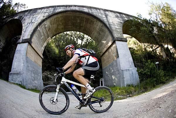 A racer passes a bridge.