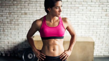 Woman in a sports bra showing off her strong core