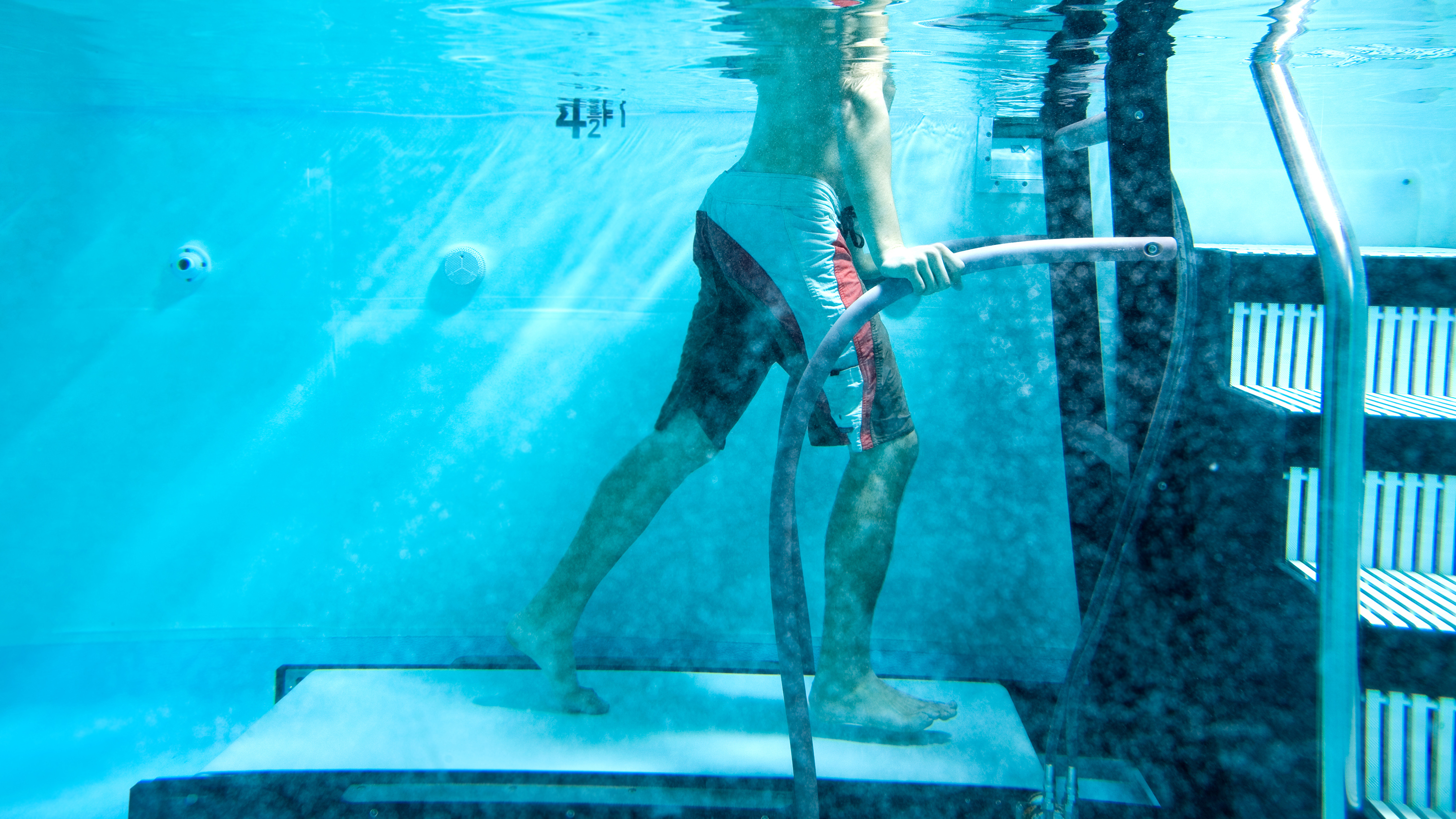 Mand bruger løbebånd under vandet