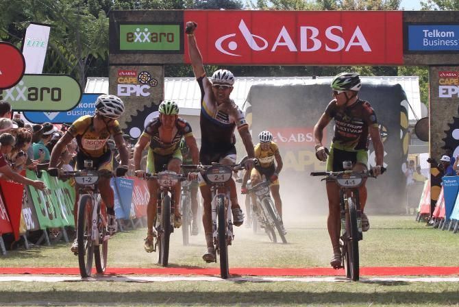 Karl Platt of the Bulls celebrates after crossing the line to complete the win with his partner Stefan Sahm (unseen) as Hannes Genze of Multivan Merida Biking (L) looks on during stage 2 of the 2012 Cape Epic