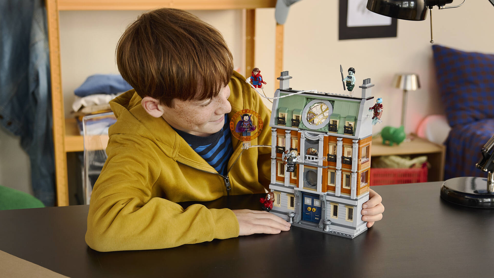 A boy smiles while holding the What If Lego Sanctum Sanctorum