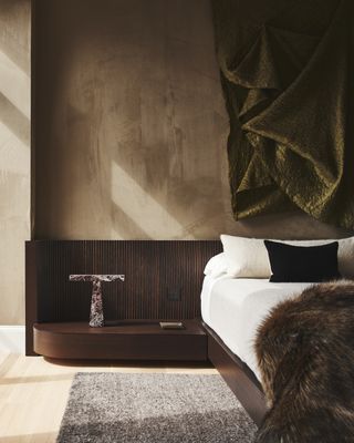 A bedroom with brown palette and a luxurious throw