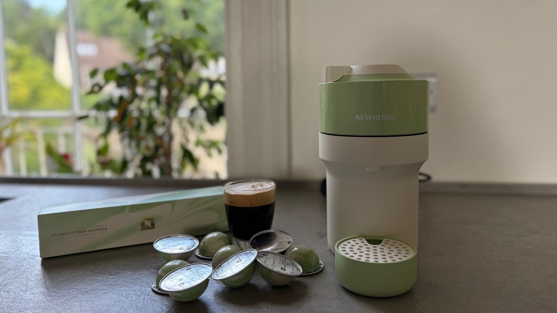 Nespresso Vertuo Pop Pistachio on the counter with the pods