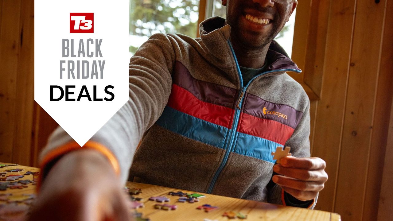 Man playing a puzzle game wearing a Cotopaxi fleece