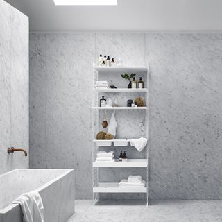 bathroom with metal shelving with towels on
