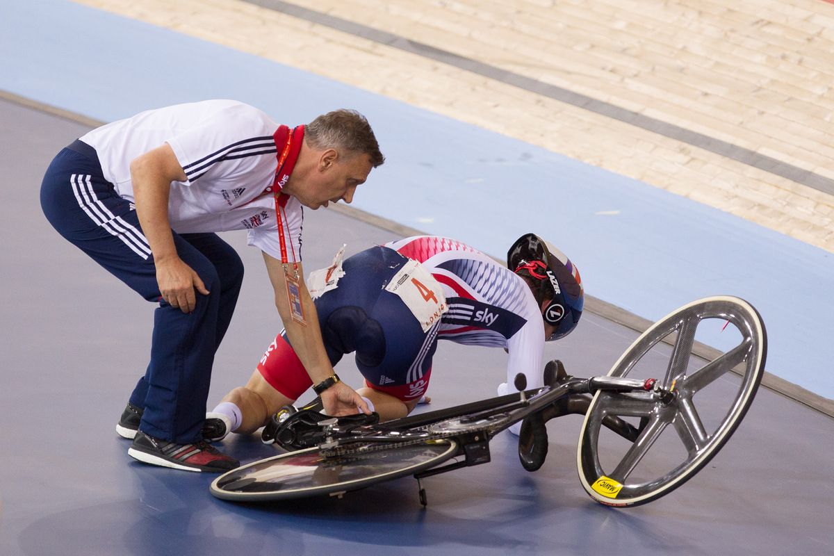 Mark Cavendish receiving assistance after his late crash in the madison