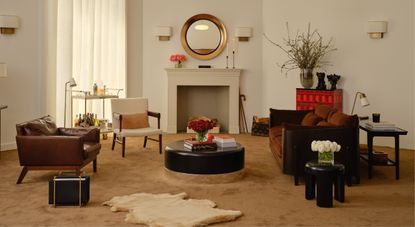 A beautifully decorated living room with a stone-sculpted fire place features a velvet brown carpet, leather and wood furniture in chocolatey brown, lots of plants and collectibles.