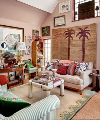 pink eclectic living room with a tall vaulted ceiling and a large rug tapestry hung on the wall