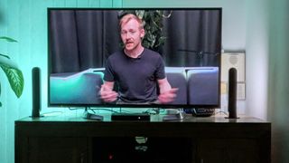 Mostly green image shown on TV with Philips Hue Play Light Bars beside it