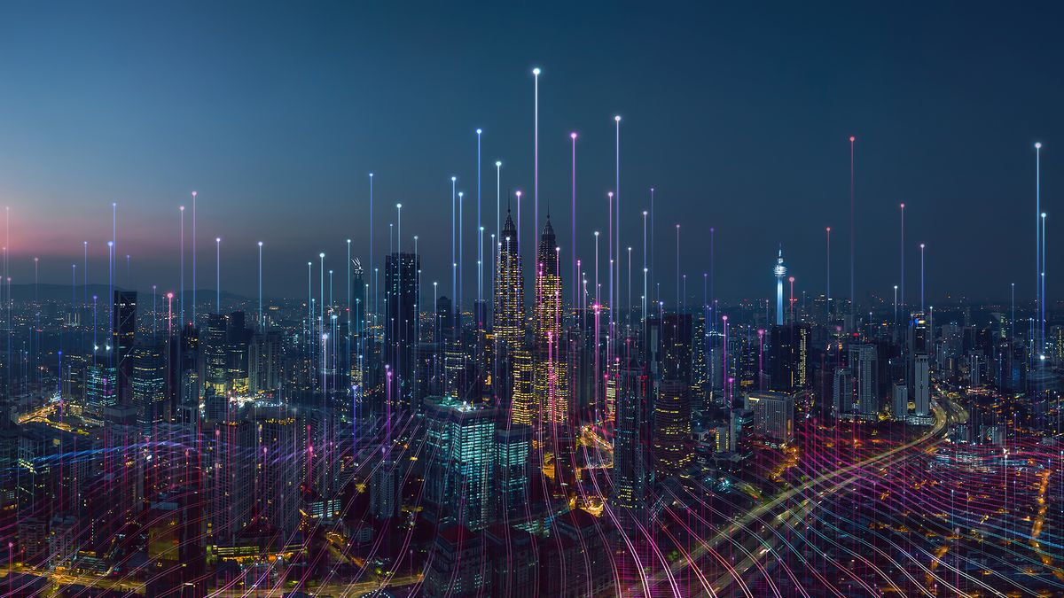 A cityscape at night with data streams riding into the sky