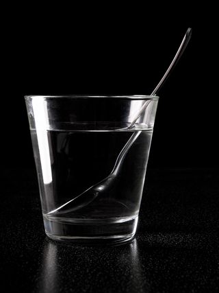 A "bent" spoon in a glass of water is an example of refraction.
