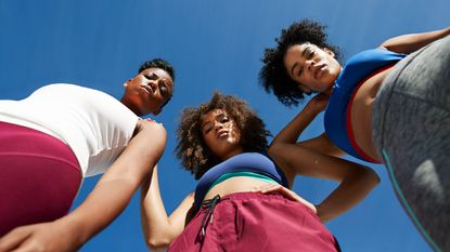 female athletes in sportswear against blue sky - stock photo