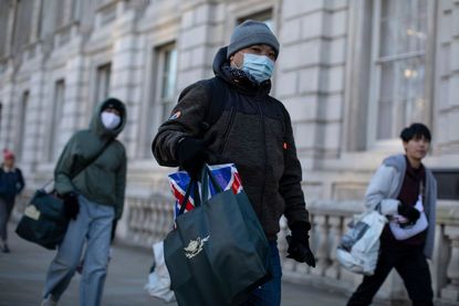 People walk around London in masks