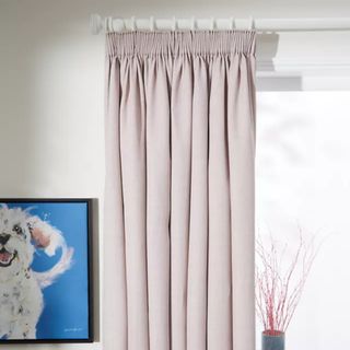 John Lewis Textured Weave Recycled Polyester Pair Blackout Thermal Lined Pencil Pleat Curtains in Rose Pink hung on a curtain pole next to a dog painting