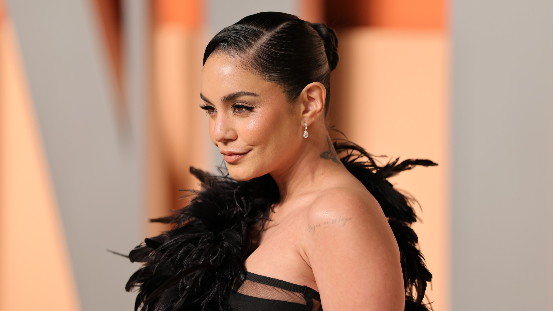 a woman with dark hair wearing a black dress on a red carpet