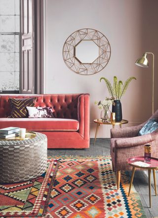 boho style living room with red sofa, wall hangings and other boho features by perch & parrow
