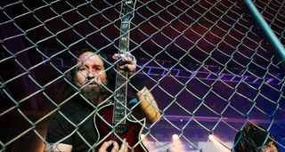 Monte Pittman of Ministry shreds on an ESP singlecut behind a metal fence onstage.