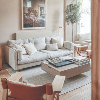 A living room with a with a cream deep sofa and a storage coffee table with clean lines