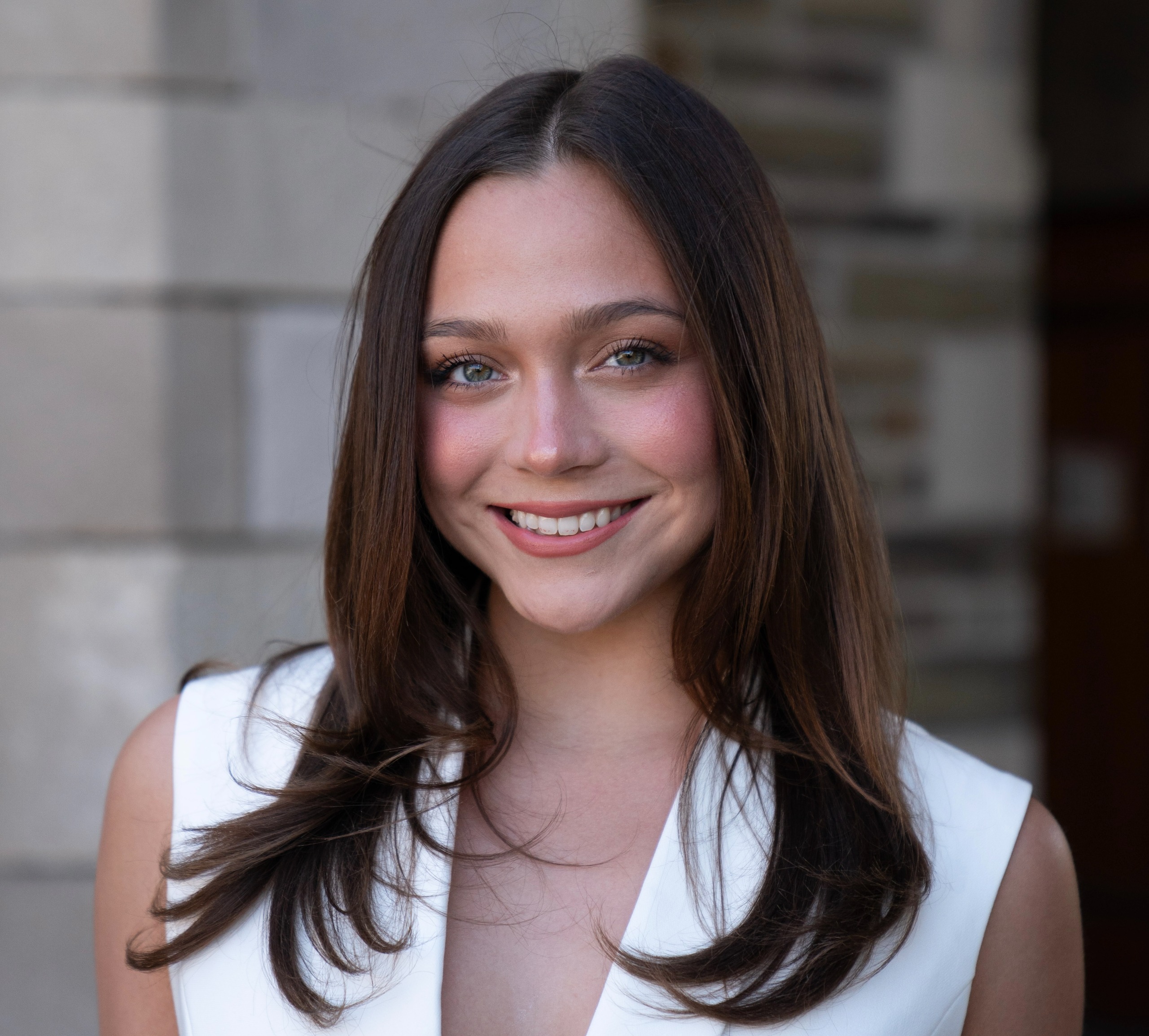 woman with long brown hair smiling to camera