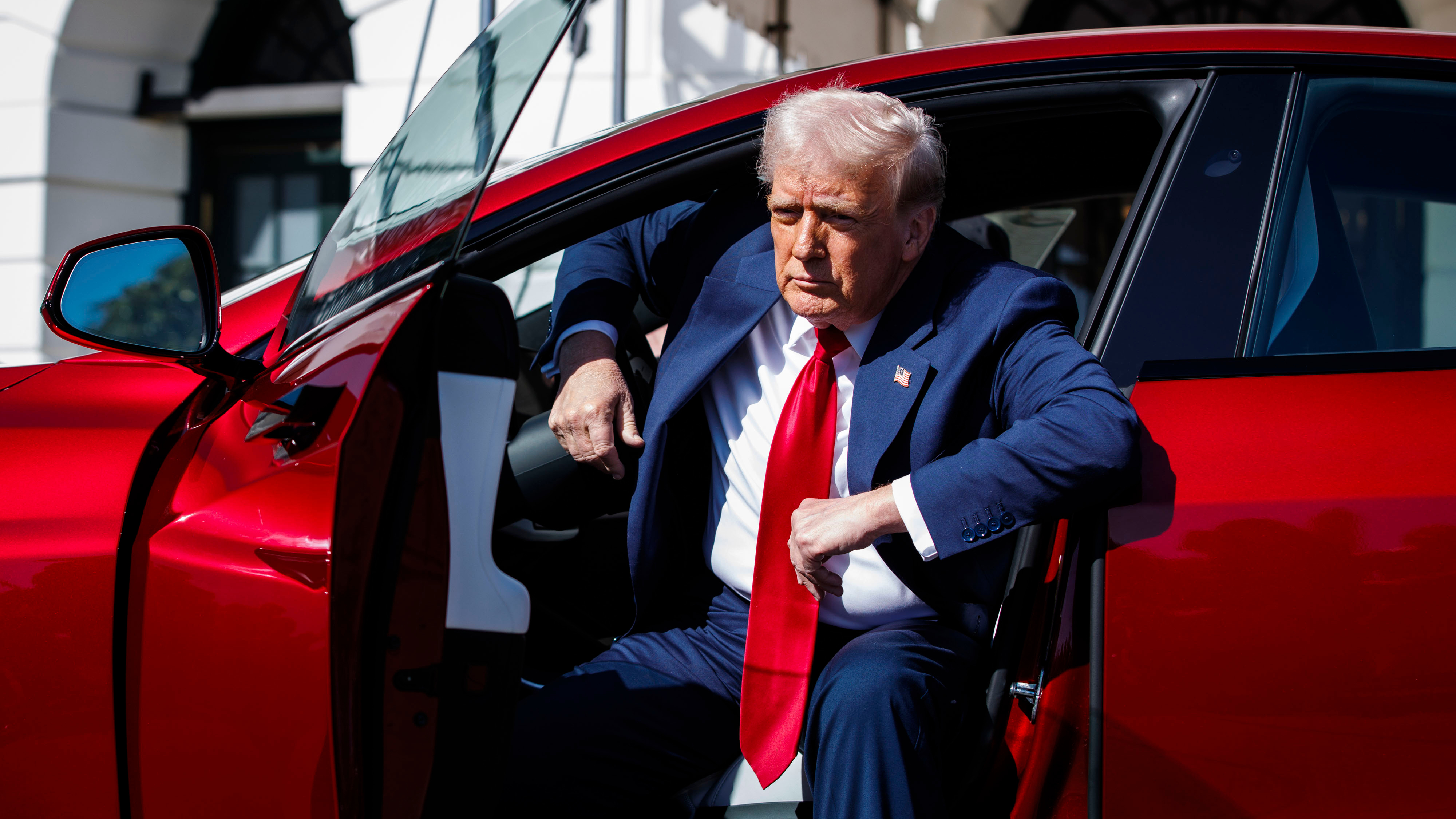 President Trump getting out of a red electric car