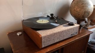 The Victrola Eastwood II turntable on a wooden surface next to a globe.