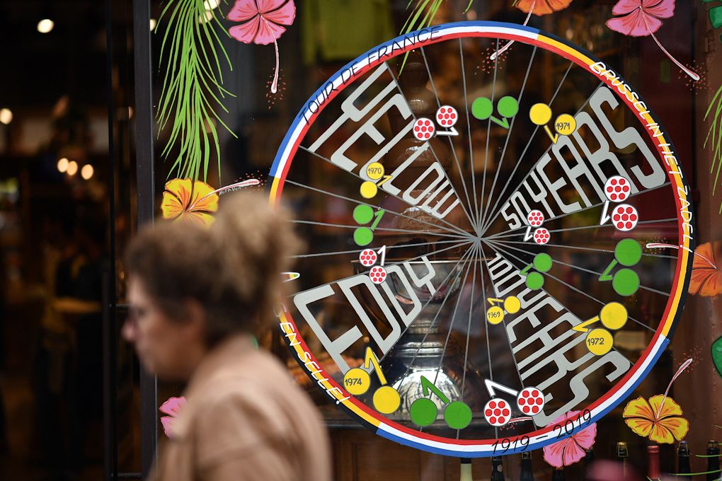 A woman passes by a bicycle wheel decorated for the 50 years anniversary of the first victory of Belgian legend Eddy Merckx in Brussels