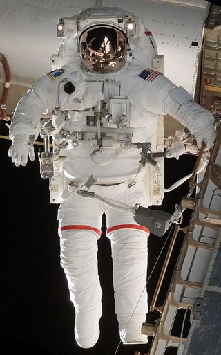An astronauts in an extravehicular activity (EVA) EMU suit during space shuttle mission STS-118.